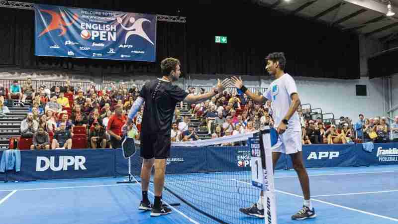 Players shaking hands at the Telford Pickleball Tournament during the English Open, with spectators in the background